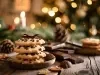 Em cima de uma mesa, em cima de um prato, biscoitos com gotas de chocolate perfilado um em cima de outro, decorado com um laço marrom.
