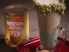 Foto da receita de cappuccino de pistache servida em um copo alto de vidro sobre uma mesa de madeira
