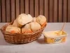 Pãezinhos de milho caseiros em cesta com margarina Deline derretendo em um pão