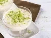 Imagem de um potinho de vidro com mousse de limão decorado com raspas de limão.