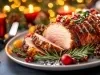 Fotografia com decorações e velas de natal. No centro tem um prato cinza raso com o tender com duas fatias cortadas e enfeites de natal.