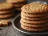 Em cima de uma mesa, prato redondo com biscoitos redondos crocantes enfileirados em cima do outro.
