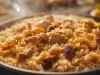 Um prato de Arroz Natal é apresentado em um prato redondo, repleto de arroz soltinho e colorido. O arroz é misturado com pedaços suculentos de peito de frango.