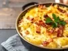 Em cima de uma mesa, refratário redondo com batata cremosa gratinada com queijo e bacon.
