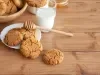 Em cima de uma mesa, prato branco com biscoitos crocantes, decorados com granulado de açúcar cristal. Ao lado do prato, copo com mel.