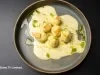 Nhoque servido com molho cremoso e toque de azeite verde, em apresentação sofisticada e perfeita para ocasiões especiais.