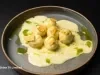Nhoque servido com molho cremoso e toque de azeite verde, em apresentação sofisticada e perfeita para ocasiões especiais.