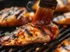 Fotografia de um peito de frango feito na churrasqueira com molho barbecue