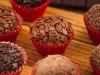 Imagem aproximada de brigadeiros gourmet em forminhas vermelhas.