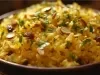 Tigela redonda com porção de arroz amarelo e soltinho com amêndoas picadas, decorado com coentro picada.