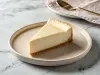 Fotografia da fatia da torta de creme de leite condensado em um prato de vidro claro raso.