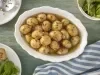 Imagem vista de cima de uma travessa branca com mini batatas temperadas