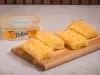 Pedaços de bolo de macaxeira com coco ralado e margarina Deline em tábua de madeira