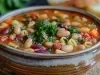 Imagem da receita de sopa de macarrão e feijão italiana, servida e uma tigela de cerâmica marrom.