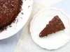 Imagem vista de cima de um prato branco com detalhes rosa e uma fatia de bolo de chocolate com brigadeiro e chocolate granulado.