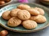Em cima de uma mesa, biscoitos redondos crocantes com listas feitas com um garfo.