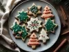 Em cima de uma mesa, prato redondo em com biscoitos em formatos de estrelas e árvore de Natal, decorado com glacê colorido.