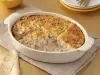 Caçarola assada de atum e salmão em molho cremoso, com superfície dourada gratinada, servida em refratário oval branco.