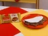 Tapioca recheada com creme de chocolate e Baton em prato vermelho, ao lado da embalagem do produto.
