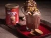 Receita de smorecaccino servida em duas canecas de vidro sobre uma mesa de madeira