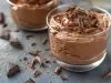 Imagem de um copinho de vidro com mousse de chocolate coberto com raspas de chocolate.