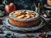 Fotografia de um bolo de maçã redondo, com crosta dourada e fatias de maçã dispostas em círculo, polvilhado com açúcar de confeiteiro. O cenário rústico inclui maçãs inteiras e elementos vintage.