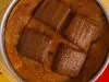 Vista superior de cookie gigante em lata metálica, coberto com pedaços de chocolate Baton.