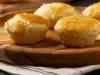 Empadinhas douradas sobre tábua de madeira, ideais para vender, com massa amanteigada e recheio variado.