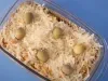 Fotografia vista de cima de um recipiente refratário retangular, de vidro, com uma receita de torta com massa de grão de bico e ascenda, finalizada com queijo parmesão e azeitonas