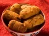Foto aproximada da receita de Bolinho de Pirarucu, servido em um pote sobre uma toalha vermelha