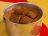 Cookie gigante assado em lata metálica, com pedaços de chocolate Baton sobre a massa dourada.