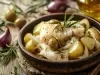Em cima de uma mesa, refratário com pedaço de bacalhau, batatas cortadas ao meio, cebolas em meia lua, decorado com alecrim.