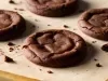 Em cima de uma mesa, biscoitos de chocolate.