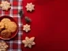 Em cima de uma mesa decorada de Natal, prato com biscoitos redondos e formado de estrelas crocantes, os biscoitos em formato de estrela estão decorados com glacê branco.