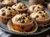 Em cima de uma mesa, prato com bolinhos de fubá e gotas de chocolate.