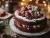 Fotografia de um bolo de chocolate festivo, com duas camadas e cobertura de açúcar de confeiteiro. Decorado com trufas de chocolate, pérolas de açúcar e enfeites que lembram ornamentos de Natal.
