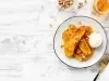 Em cima de uma mesa, prato redondo com bananas fritas, no meio sorvete de coco.