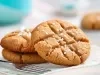 Em cima de uma mesa, prato redondo com biscoitos redondos e crocantes.