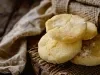Em cima de uma mesa, prato com biscoitos dourados e crocantes.