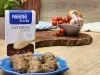 Fotografia em tons de marrom claro com um prato azul ao centro. Em cima do prato existem algumas almôndegas feitas com Farelo de Aveia NESTLÉ e recheadas com queijo muçarela. Ao fundo existe uma embalagem de NESTLÉ Farelo de Aveia