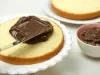 Foto de um bolo aberto ao meio em cima de um prato branco sendo preenchido com creme de chocolate por cima