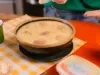 Caldo cremoso de macaxeira com rodelas de linguiça calabresa e cheiro-verde