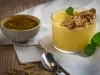 Fotografia em tons de amarelo em uma bancada de madeira, um paninho bege, um potinho com um creme de iogurte de maracujá com gengibre. Ao lado, um potinho de maracujá e uma colher.