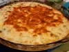 Um recipiente de vidro transparente apresenta um queijo gratinado dourado, com uma crosta crocante.