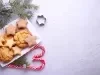 Em cima de uma mesa, prato retangular com biscoitos em formato de árvore de Natal e estrelas, decorados com açúcar de confeiteiro.