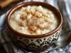 Imagem de um bowl rústico com a receita de arroz doce cremosa polvilhada com canela em pó.