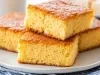 Fotografia de três pedaços de cornbread empilhados em um prato branco, com uma crosta dourada e interior macio, destacando sua aparência fresca e apetitosa