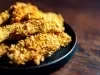 Fotografia de uns peitos de frango empanados e crocantes, parte de uma receita de sambiquira.