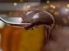 Fotografia de uma colher de sopa segurando um pouco do brigadeiro cremoso de chocolate.
