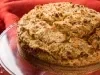 Fotografia de uma receita inteira de cuca alemã tradicional sobre um apoio de vidro raso.